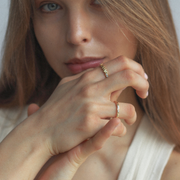 Close-up of a woman wearing gold rings on her fingers.