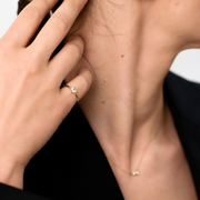 Woman's hand wearign a 14k yellow gold ring with two pear-shaped diamonds set in the band.