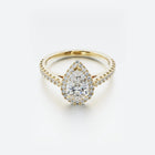 Gold ring with a pear-shaped diamond on a white background