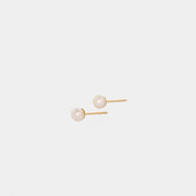 A pair of yellow gold stud earrings with round pearl embellishments.
