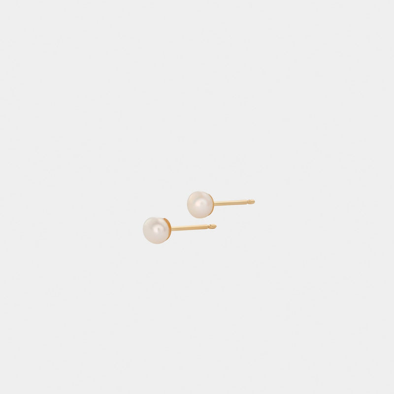 A pair of yellow gold stud earrings with round pearl embellishments.