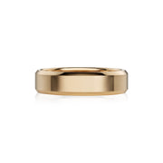 A polished yellow gold band ring with a smooth, slightly beveled edge, shown on a clean white background with a soft reflection underneath.