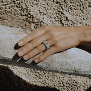 Hand wearing one-of-a-kind ring composed of tantalum and rough Columbian emerald by ASR JWLS.