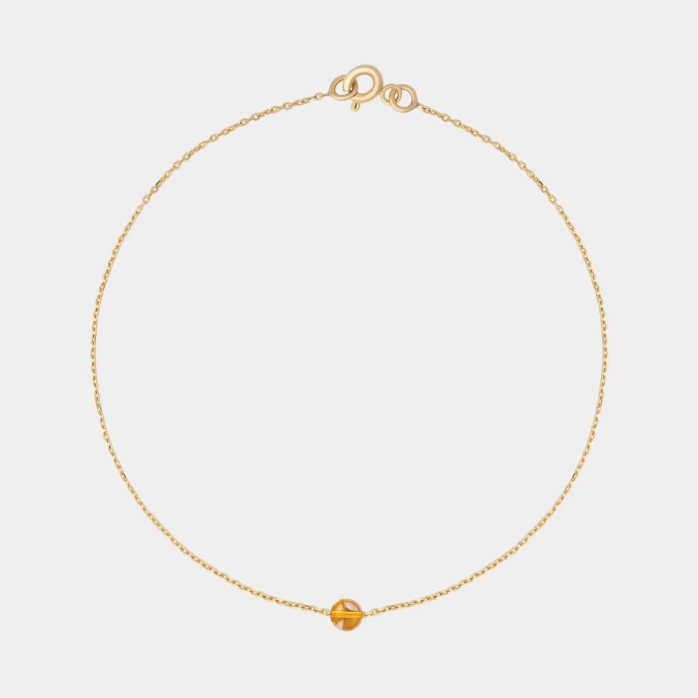Gold bracelet with small Baltic amber by Adele Notes.