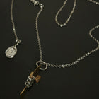 Silver necklace with a fish pendant on a dark background