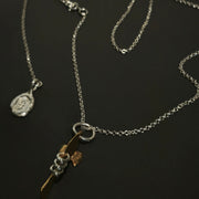 Silver necklace with a fish pendant on a dark background