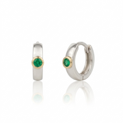 Pair of hoop earrings with emeralds on a white background