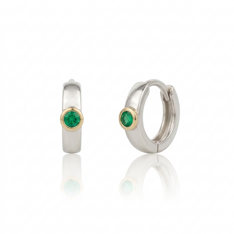 Pair of hoop earrings with emeralds on a white background