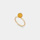 A sleek gold ring featuring a medium size natural Baltic amber stone.