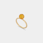 A sleek gold ring featuring a medium size natural Baltic amber stone.