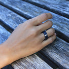 Hand wearing a one-of-a-kind rings composed of niobium and a white diamond by ASR JWLS.
