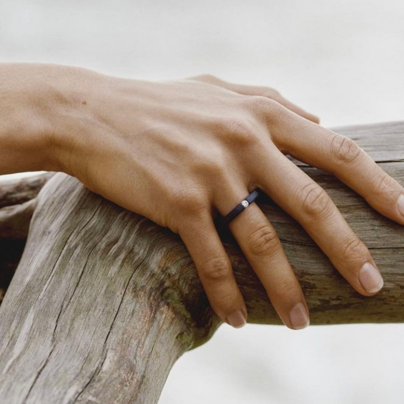 Hand wearing a one-of-a-kind ring composed of niobium and a white diamond by ASR JWLS.