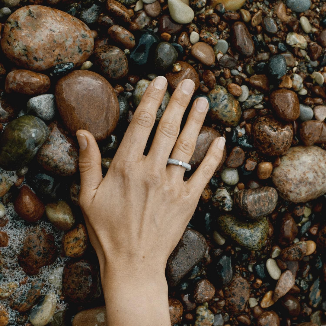 Hand wearing one-of-a-kind ring composed of tantalum and a white diamond by ASR JWLS.