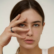 Woman wearing a one-of-a-kind ring composed of niobium and a white diamond by ASR JWLS.