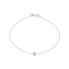 A 14k white gold bracelet with a single white diamond, featuring a simple chain design.