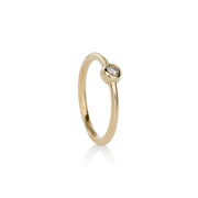 A 14k yellow gold ring with a single white diamond set in a gold band, with a polished finish.
