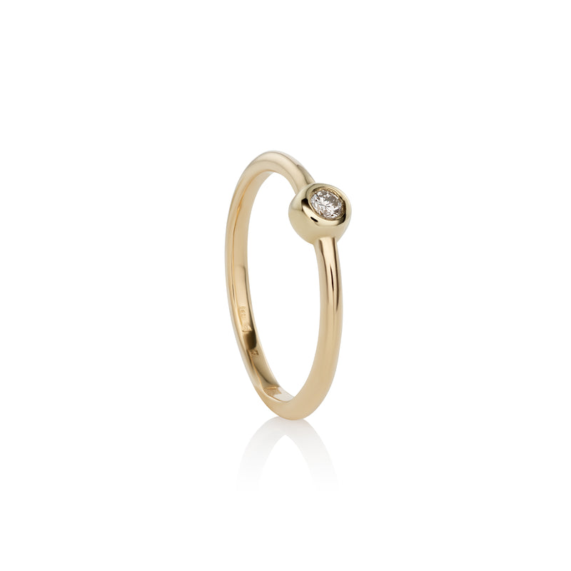 A 14k yellow gold ring with a single white diamond set in a gold band, with a polished finish.