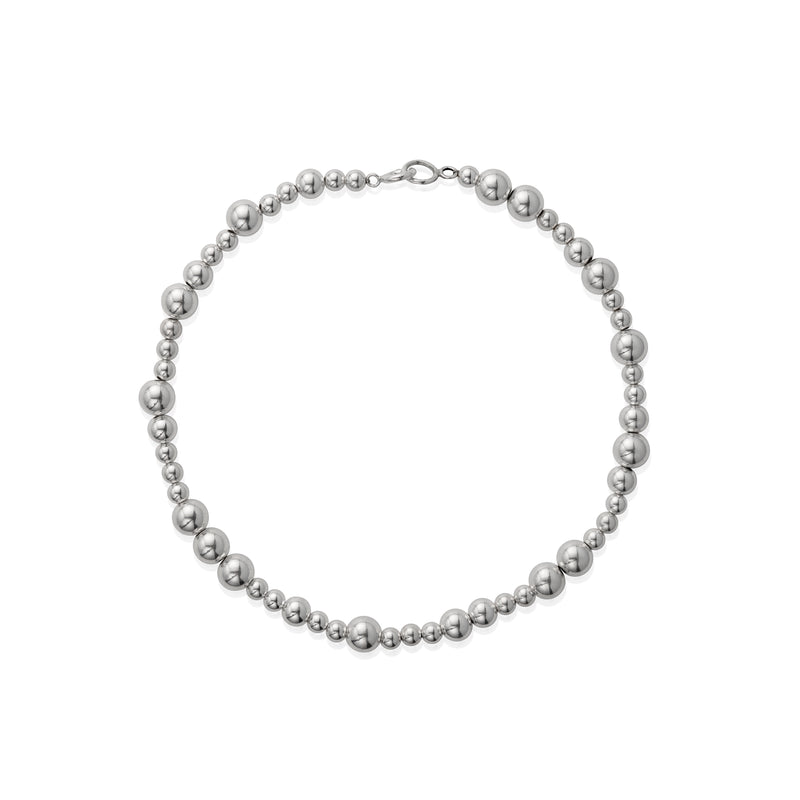 A silver necklace with varying sizes of beads, displayed against a white background.