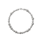 A necklace with varying sized silver beads strung together on a chain.