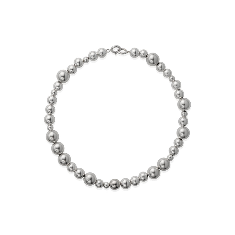 A necklace with varying sized silver beads strung together on a chain.