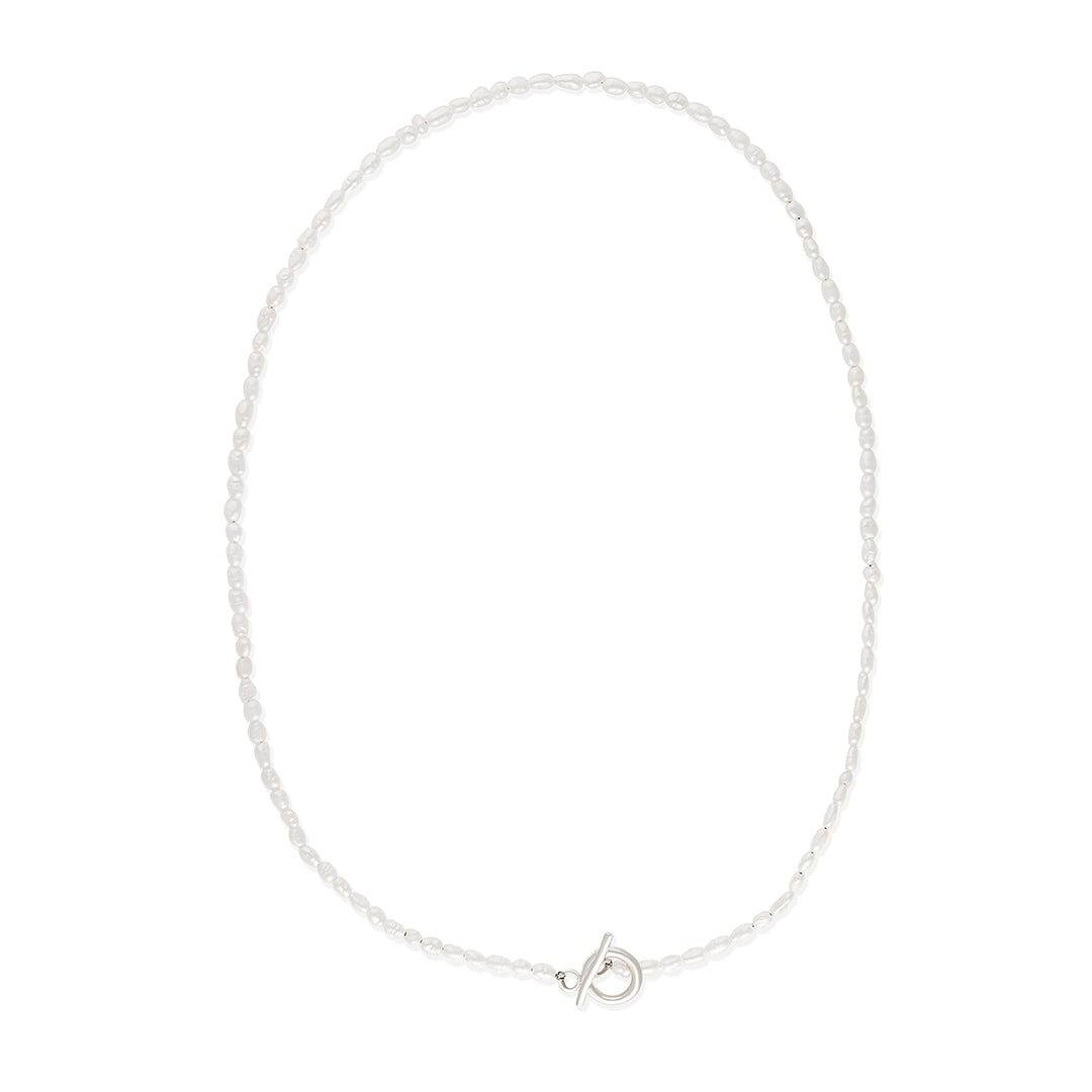 Delicate freshwater pearl necklace featuring organically shaped pearls and a minimalist silver clasp against white background.