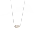 Baroque-shaped freshwater pearl suspended from a delicate white gold chain on a white background.