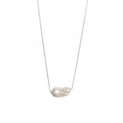 Baroque-shaped freshwater pearl suspended from a delicate white gold chain on a white background.