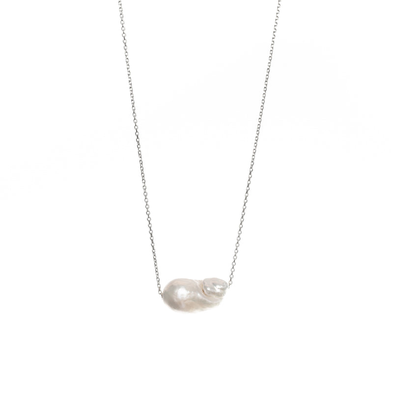 Baroque-shaped freshwater pearl suspended from a delicate white gold chain on a white background.