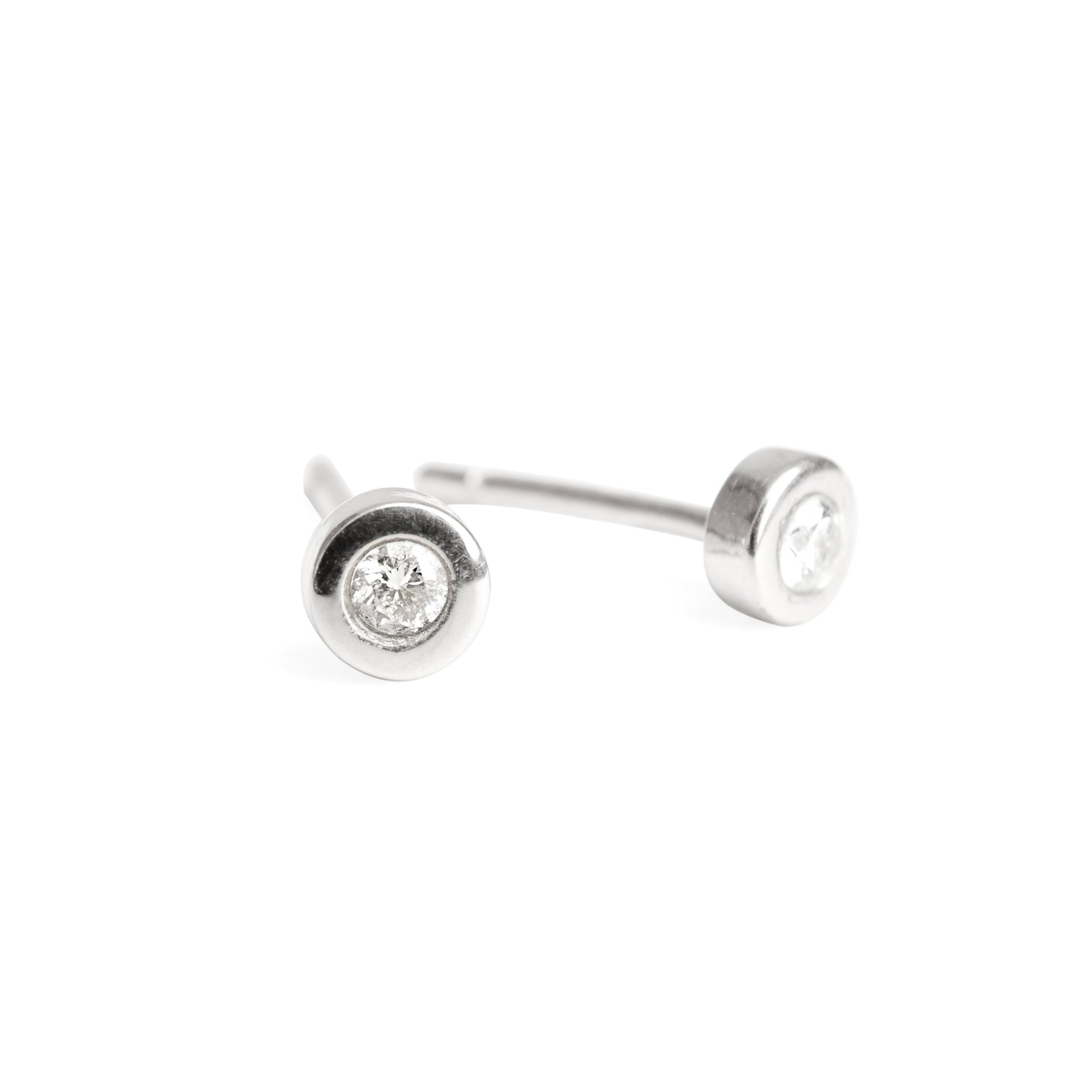 A pair of 14k white gold stud earrings with diamonds set in them.