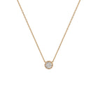 Yellow gold pendant featuring a round brilliant-cut diamond, suspended from a delicate gold chain. 