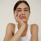 Woman wearing one-of-a-kind ring composed of tantalum and rough Columbian emerald by ASR JWLS.