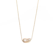 Unique baroque-shaped freshwater pearl suspended from a delicate yellow gold chain. 
