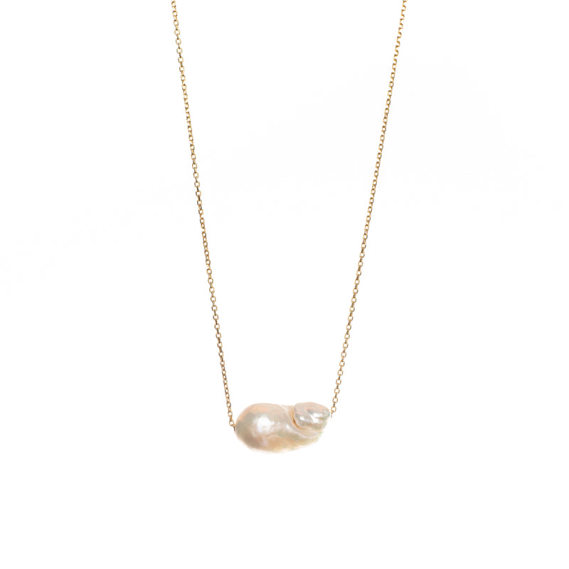Unique baroque-shaped freshwater pearl suspended from a delicate yellow gold chain. 